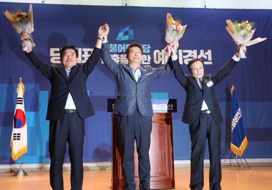 26일 오후 국회 의원회관에서 열린 더불어민주당 당대표 선출을 위한 예비경선대회에서 투표를 통해 예비경선을 통과한 3명의 후보가 손을 맞잡고 있다. 왼쪽부터 김진표, 송영길, 이해찬 후보.  연합뉴스